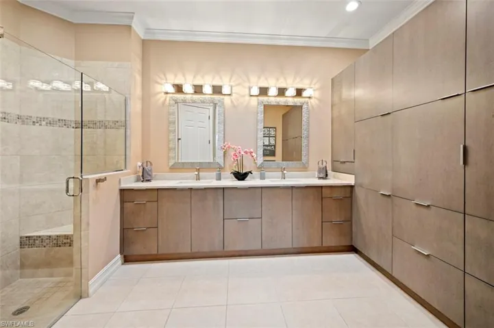 Full bath featuring double vanity, a shower stall, crown molding, tile patterned floors, and recessed lighting
