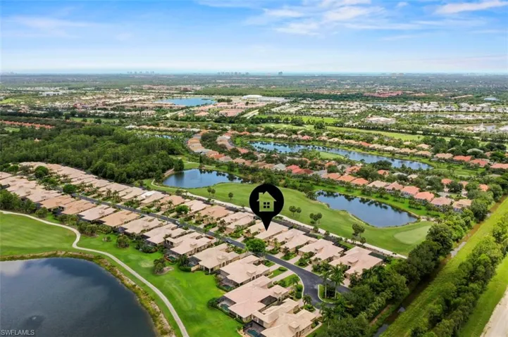 Aerial overview of property's location featuring a golf course and nearby suburban area