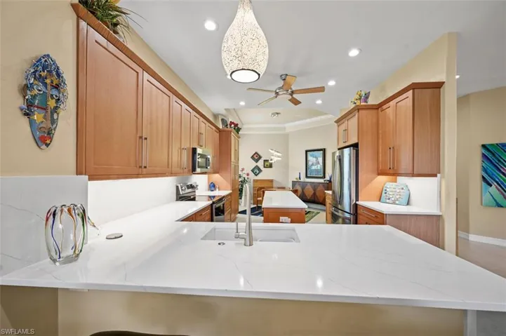 Kitchen with stainless steel appliances, a peninsula, recessed lighting, a center island, and ceiling fan