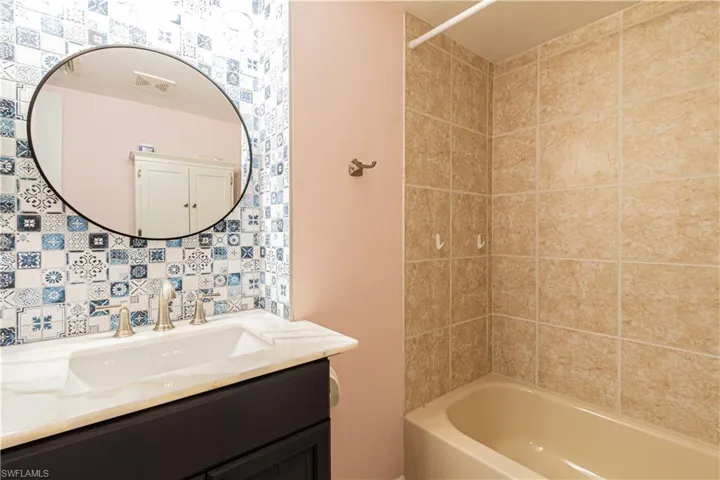 Bathroom featuring vanity and tiled shower / bath