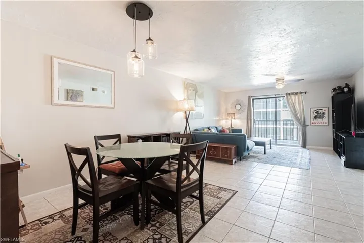 Tiled dining area featuring a textured ceiling and ceiling fan