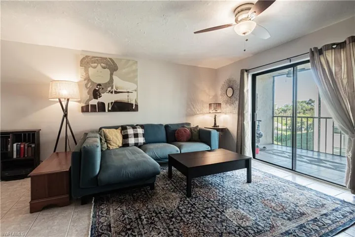 Tiled living room with ceiling fan and a textured ceiling