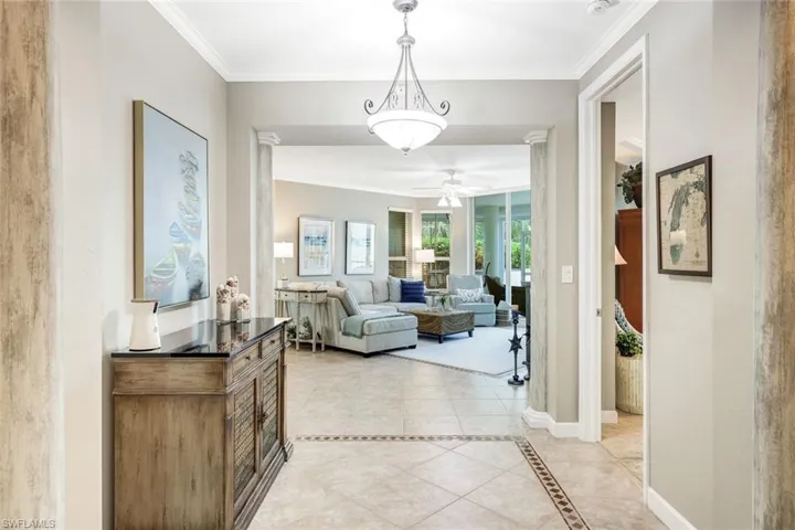 Corridor featuring ornamental molding and light tile patterned floors