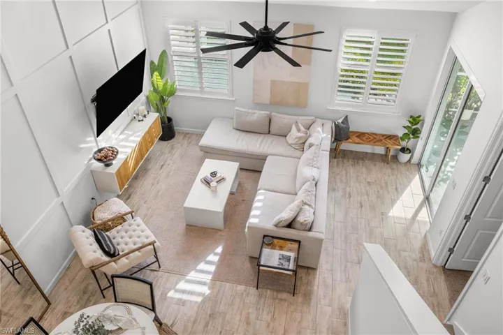 Spacious living area featuring wood-finish flooring and an expansive accent wall with panel molding