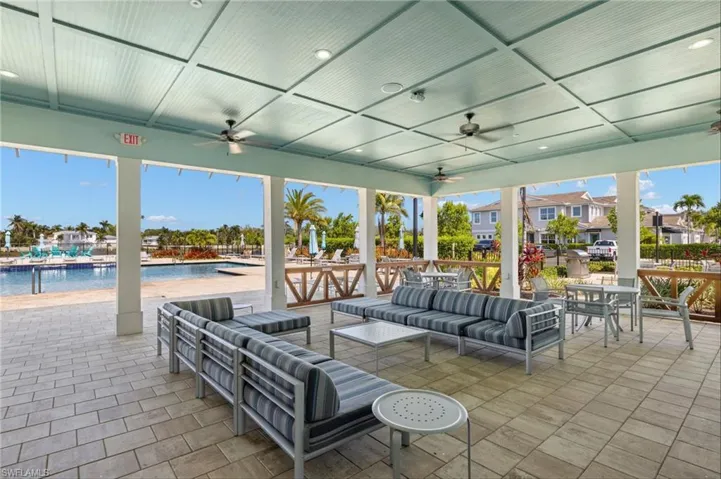 Covered outdoor patio area featuring a coffered ceiling with recessed lighting and ceiling fans