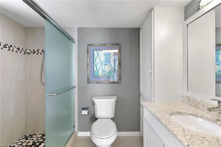 Full bathroom featuring a shower stall, vanity, and light tile patterned floors