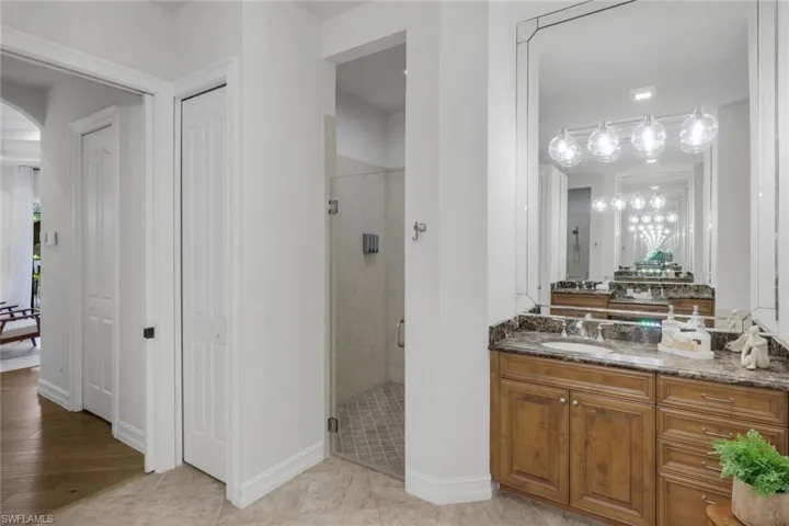 Bathroom with vanity, a stall shower, and a closet
