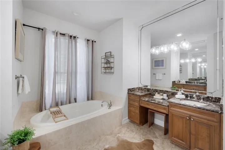 Full bath featuring vanity and a bath