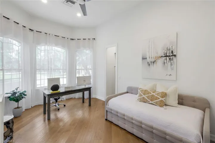 Bedroom featuring wood-type flooring, a desk, and ceiling fan