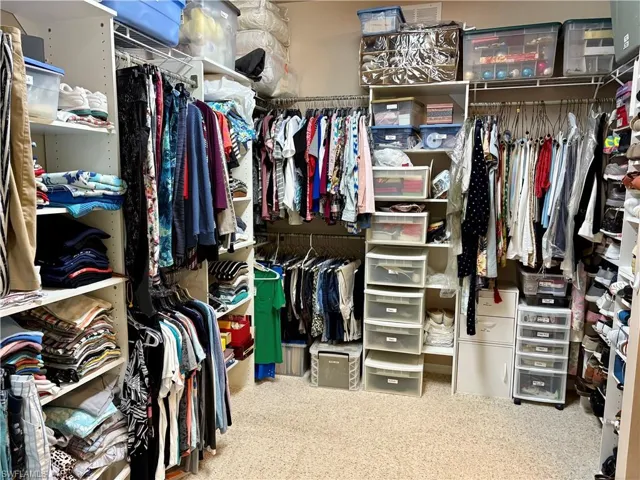 Custom walk-in Primary closet featuring carpet