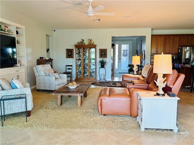 Living room with light tile patterned floors and ceiling fan