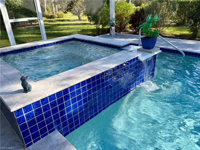View of pool featuring an in ground hot tub and pool water feature