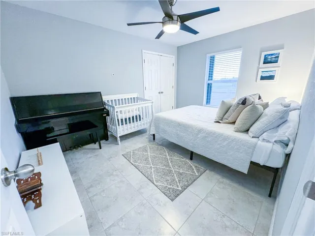 Bedroom with tile flooring, a closet, and ceiling fan