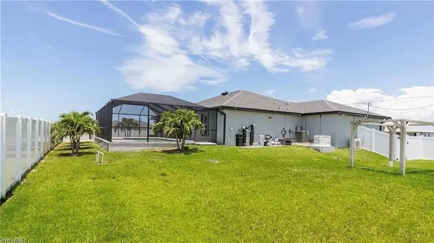 Back of house with a patio area, a lanai, a pool, and a yard