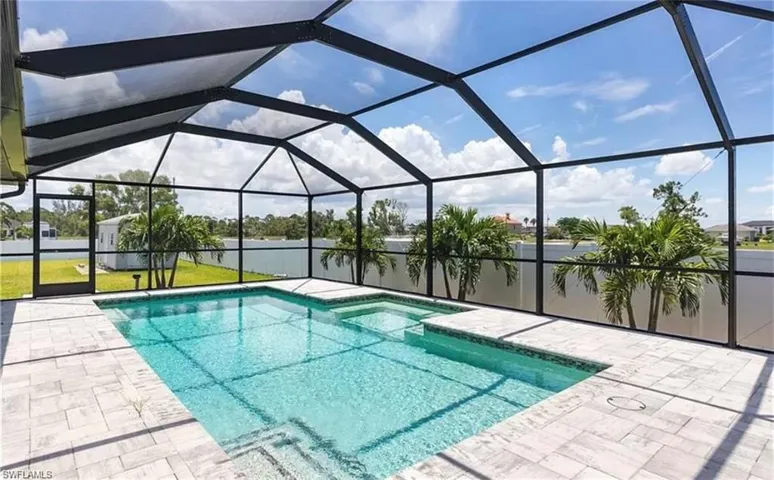 View of pool with a patio and glass enclosure
