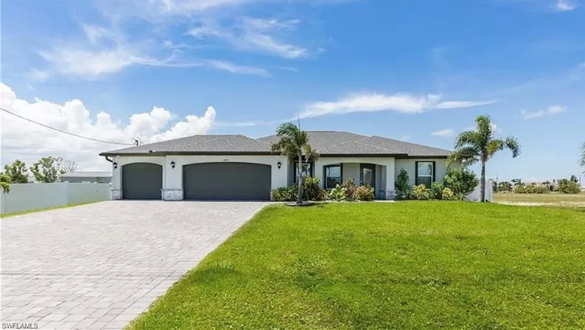 Single story home featuring a garage and a front yard