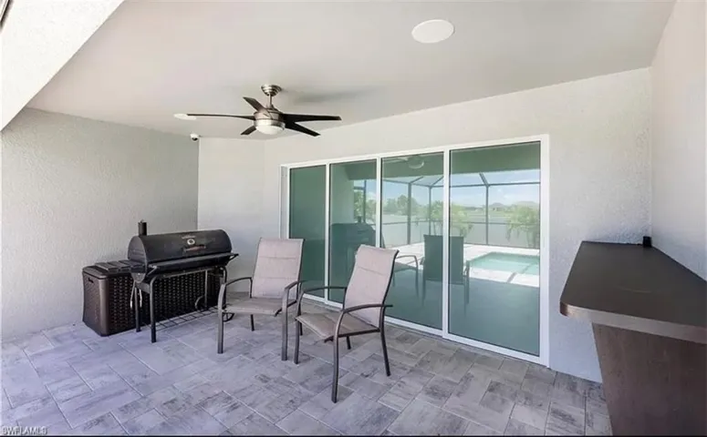 View of patio with area for grilling and ceiling fan