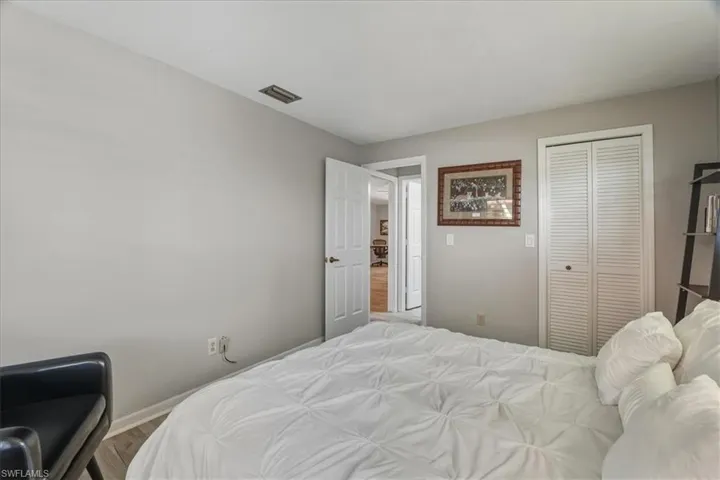 Bedroom with wood finished floors and a closet