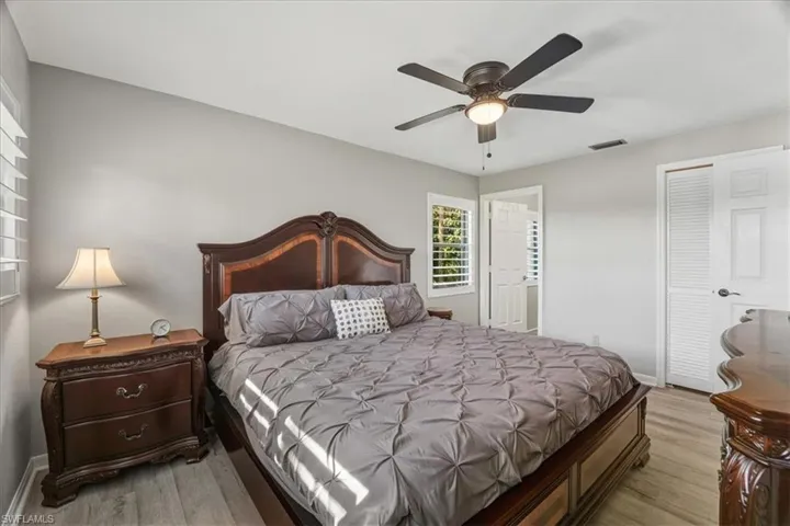 Bedroom with light wood finished floors, ceiling fan, and a closet