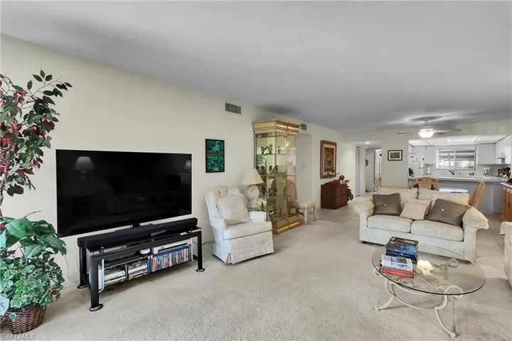 Carpeted living area with a ceiling fan