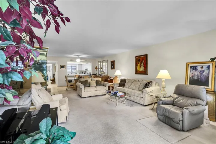 Carpeted living area with ceiling fan
