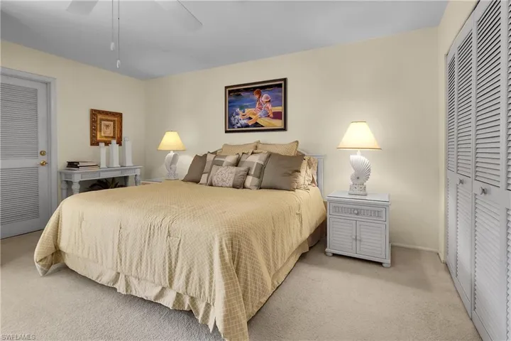 Carpeted bedroom with a closet and a ceiling fan