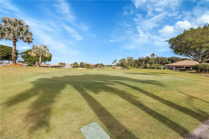 View of property's community with view of golf course and a yard