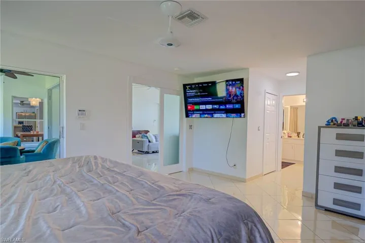 Bedroom featuring light tile patterned floors and ensuite bathroom