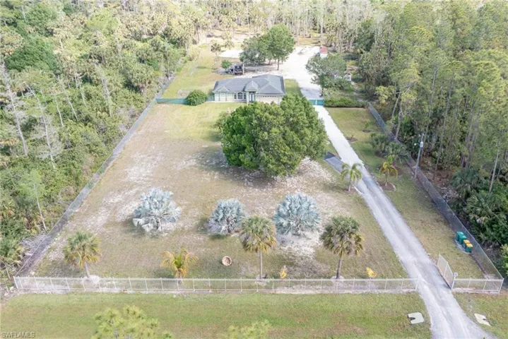 Aerial view of property and surrounding area with a forest