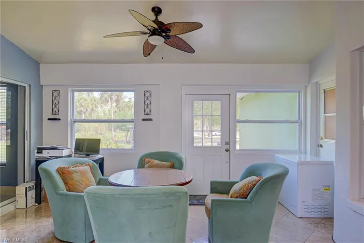 Living room featuring light tile patterned floors and ceiling fan