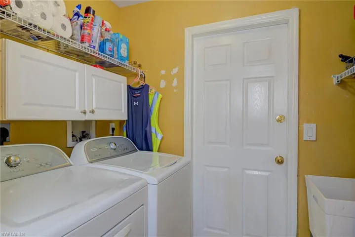 Washroom featuring washer and clothes dryer and cabinet space