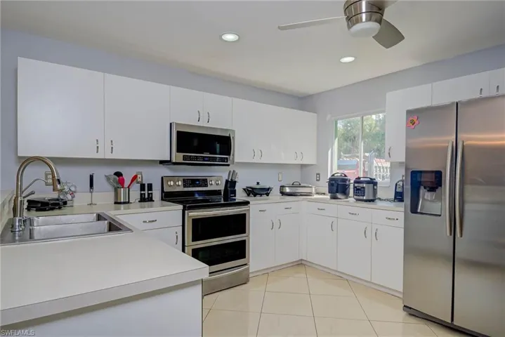 Kitchen featuring appliances with stainless steel finishes, light countertops, ceiling fan, light tile patterned floors, and recessed lighting