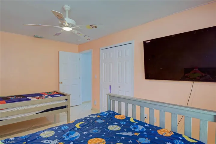 Tiled bedroom featuring a closet and ceiling fan