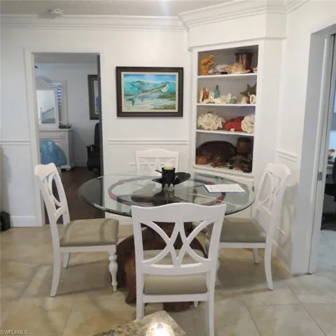 Tiled dining space with ornamental molding and a textured ceiling