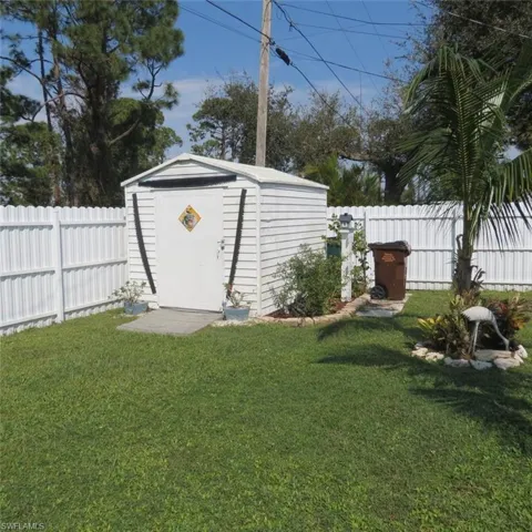 View of outdoor structure featuring a lawn