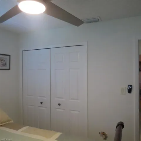 Bedroom with ceiling fan and a closet