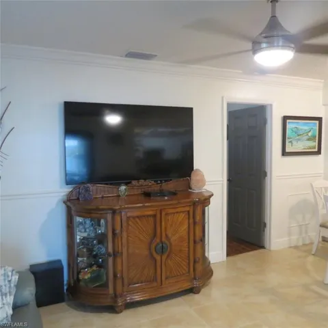 Living room with ornamental molding and tile patterned flooring