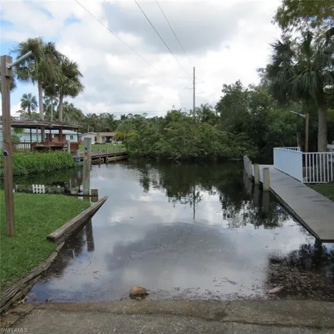 Dock area with a water view and a yard