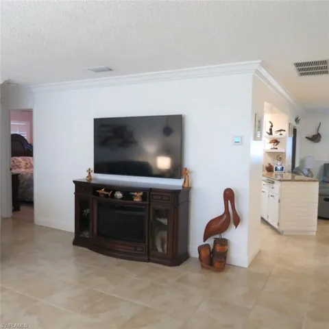 Tiled living room with ornamental molding and a textured ceiling