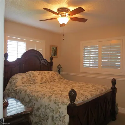 Bedroom with ceiling fan and a textured ceiling