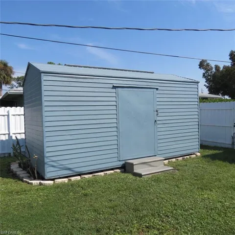 View of outdoor structure with a yard