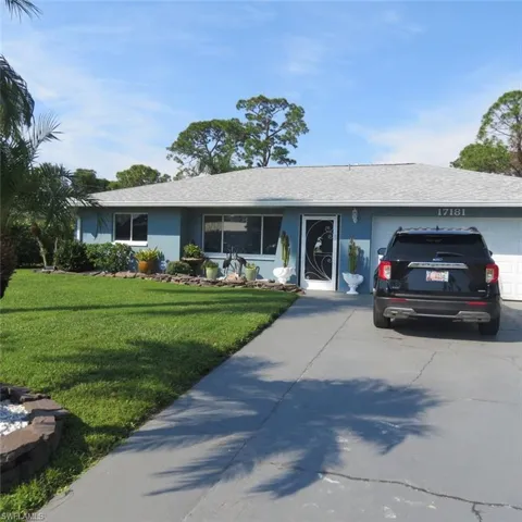 Ranch-style house featuring a front yard and a garage