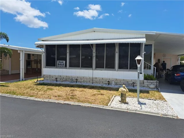 Manufactured / mobile home with a carport and a sunroom