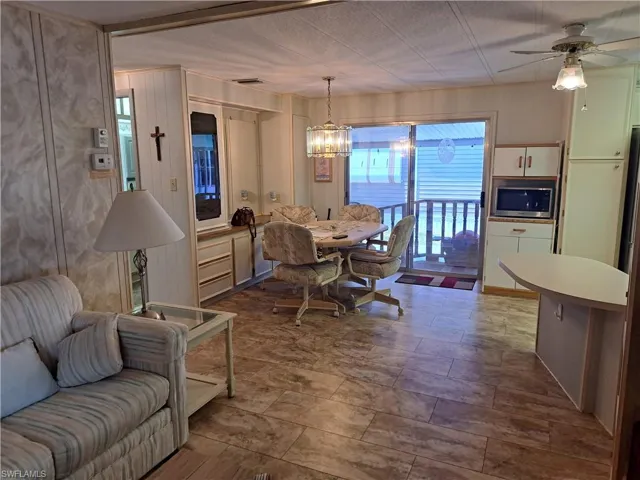 Dining room featuring tile flooring and ceiling fan with notable chandelier