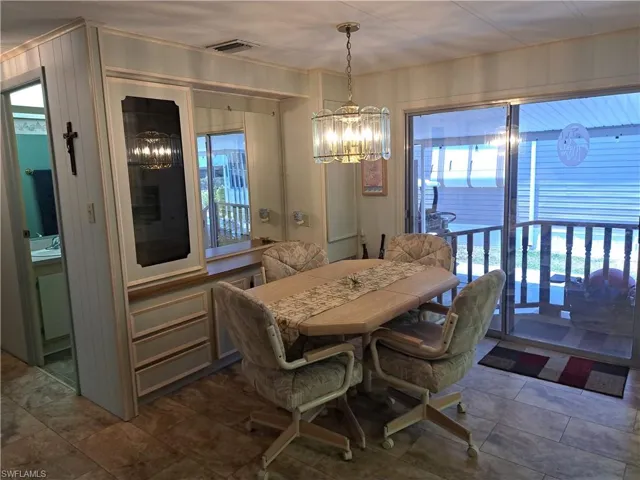 Tiled dining room featuring an inviting chandelier and sink
