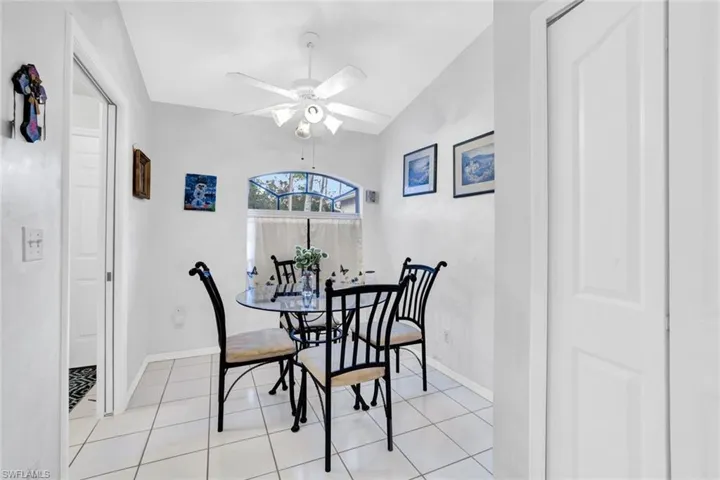 Dining room featuring lofted ceiling, light tile patterned floors, and ceiling fan