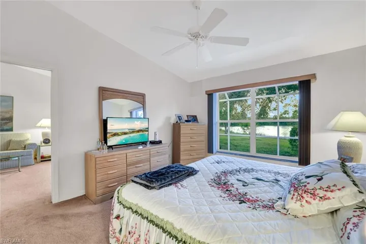 Carpeted bedroom with vaulted ceiling and ceiling fan