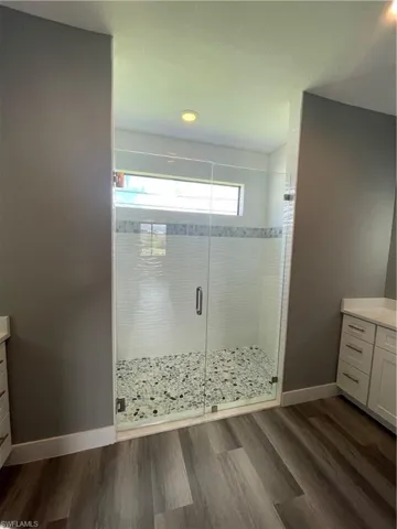 Bathroom with vanity, a stall shower, dark wood-style floors, and recessed lighting