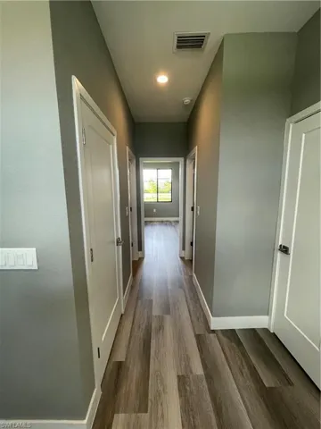 Hall with wood finished floors and recessed lighting