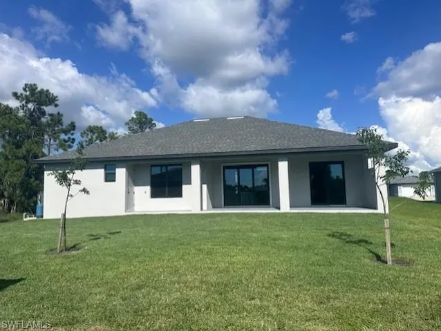 Rear view of house featuring a yard-actual home
